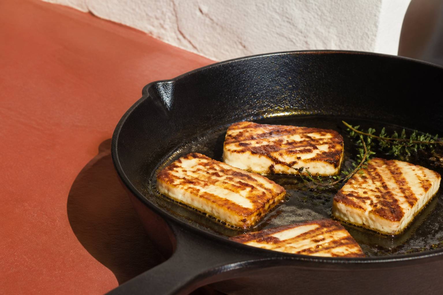 Tranches de halloumi grésillant dans une poêle en fonte